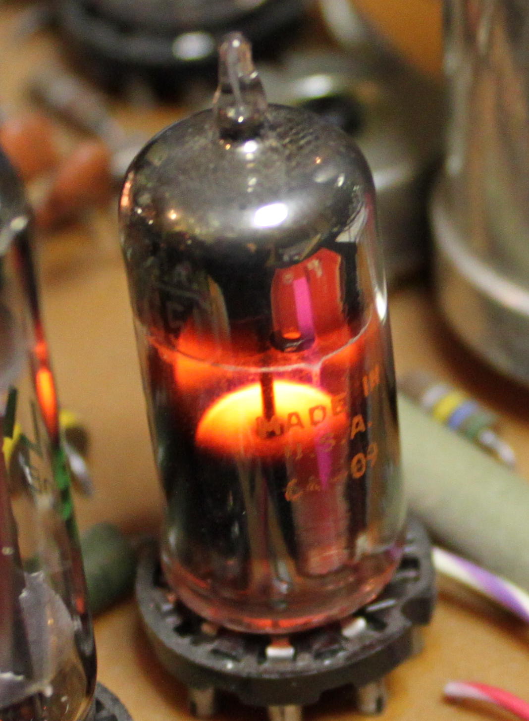 Figure 5 — 5 — A cold-cathode voltage-regulator / reference tube (a subminiature 5651) glowing in operation: the discharge covers the cathode with the characteristic soft violet glow, the visible sig…
